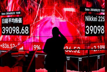 A visitor using his smartphone takes photos of an electronic screen displaying Japan's Nikkei share average, which surged past an all-time record high scaled in December 1989, inside a building in Tokyo, Japan February 22, 2024.