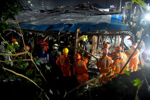 Members of rescue teams search for survivors amidst the debris after a massive billboard fell during a rainstorm in Mumbai, India, May 13, 2024.