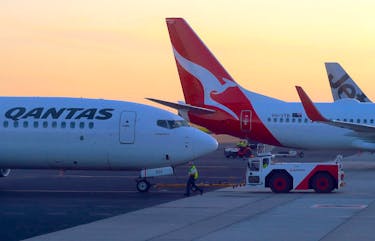 Workers are seen near Qantas Airways, Australia's national carrier, Boeing 737-800 aircraft on the tarmac at Adelaide Airport, Australia, August 22, 2018.