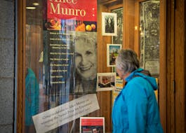 A customer looks at a window display congratulating Canadian author Alice Munro at bookstore Munro's Books after she won the Nobel Prize for Literature in Victoria, British Columbia October 10, 2013.