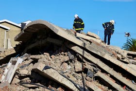 Rescuers work to rescue construction workers trapped under a building that collapsed in George, South Africa May 8, 2024.