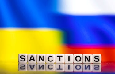 Plastic letters arranged to read "Sanctions" are placed in front of Ukraine's and Russia's flag colors  in this illustration taken February 25, 2022.