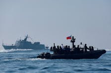 Members of Taiwan's Navy and media onboard a special operation boat navigate near a Kuang Hua VI-class missile boat, during a drill part of a demonstration for the media, to show combat readiness ahead of the Lunar New Year holidays, on the waters near a military base in Kaohsiung, Taiwan January 31, 2024.