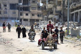 Displaced Palestinians make their way as they flee Jabalia after the Israeli military called on residents to evacuate, amid the ongoing conflict between Israel and Hamas, in the northern Gaza Strip May 14, 2024.