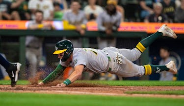 May 11, 2024; Seattle, Washington, USA; Oakland Athletics third baseman Brett Harris (77) scores on a wild pitch during the ninth inning against the Seattle Mariners at T-Mobile Park. Mandatory Credit: Stephen Brashear-USA TODAY Sports