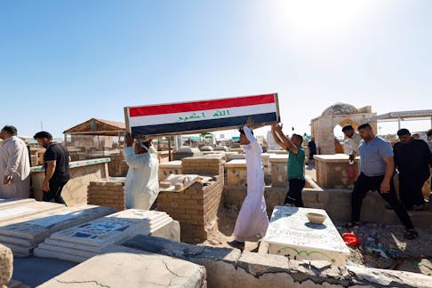 Men carry a coffin of an Iraqi soldier at the Wadi al-Salam cemetery, Arabic for "Peace Valley",  who was killed in an attack by Islamic State militants on an army post in a rural area between Diyala and Salahuddin provinces, during the funeral in Najaf, Iraq, May 14, 2024.