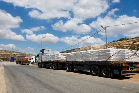 Trucks carrying aid to Gaza wait near a checkpoint near Hebron in the Israeli-occupied West Bank May 14, 2024.