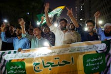 People hold a banner as they chant slogans in support of an alliance of civil rights groups protesting in Pakistan-ruled Kashmir, demanding the government give the region a subsidy on electricity and wheat prices in the face of rising inflation, during a demonstration in Karachi, Pakistan May 13, 2024.