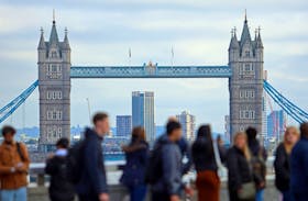 People walk over London Bridge looking at a view of Tower Bridge in the City of London financial district in London, Britain, October 25, 2023. 