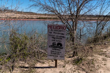 A sign warns migrants of the extreme danger of attempting to cross into the United States through the floating barriers in the Rio Grande River in Piedras Negras, Coahuila, Mexico, February 25, 2024.
