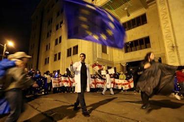 Demonstrators carry flags during a rally to protest against a bill on "foreign agents" in Tbilisi, Georgia, May 13, 2024.
