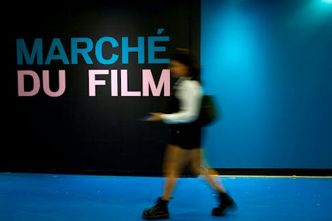 A woman walks past the Film Market business entrance before the start of the 77th Cannes Film Festival in Cannes, France, May 13, 2024.