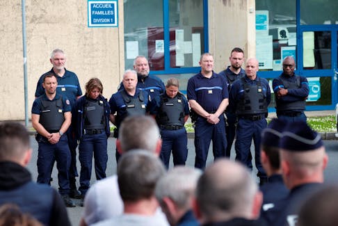Prison staff observe a moment of silence at the Detention Center after gunmen freed a drug dealer, killing two prison guards and severely wounding three others, in Val De Reuil, France, May 15, 2024.