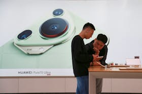 A man checks a Huawei smartphone at Huawei's flagship store in Shanghai, China May 10, 2024.