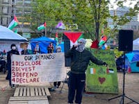 A pro-Palestinian protester speaks to the media and dozens of supporters before a press conference at the encampment at McGill University on Friday evening, May 10, 2024, after the university said it is filing a court injunction to remove the camp.  