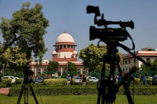 Members of media speak in front of cameras after a panel of the Supreme Court said it was divided on a decision to allow hijabs in classrooms, outside the premises of the court in New Delhi, India October 13, 2022.