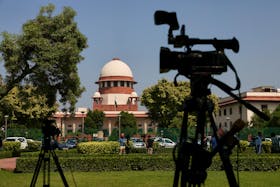 Members of media speak in front of cameras after a panel of the Supreme Court said it was divided on a decision to allow hijabs in classrooms, outside the premises of the court in New Delhi, India October 13, 2022.
