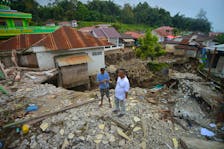 Men stand near a damaged house in an area affected by heavy rain brought flash floods in Tanah Datar, West Sumatra province, Indonesia, May 14, 2024, in this photo taken by Antara Foto. Antara Foto/Iggoy el Fitra/via REUTERS