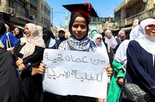 A demonstrator holds a sign that says "From Amman, greetings to the American students" during a protest in support of Palestinians in Gaza, amid the ongoing conflict between Israel and the Palestinian Islamist group Hamas, in Amman, Jordan May 3, 2024.