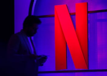 A man stands next to a logo of Netflix during an event in Mumbai, India, February 29, 2024.