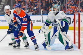 May 14, 2024; Edmonton, Alberta, CAN; Edmonton Oilers forward Dylan Holloway (55) battles with Vancouver Canucks defensemen Tyler Myers (57) in front of goaltender Arturs Silovs (31) during the first period in game four of the second round of the 2024 Stanley Cup Playoffs at Rogers Place. Mandatory Credit: Perry Nelson-USA TODAY Sports