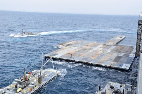 U.S. Army Soldiers assigned to the 7th Transportation Brigade (Expeditionary) and U.S. Navy sailors attached to the MV Roy P. Benavidez assemble the Roll-On, Roll-Off Distribution Facility (RRDF), or floating pier, to assist in the delivery of humanitarian aid to the people of Gaza, in the Mediterranean Sea April 26, 2024.   U.S. Army Central/Handout via REUTERS./File Photo
