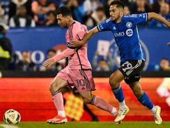  Lionel Messi dribbles the ball against Mathieu Choinière of CF Montréal during the second half at Saputo Stadium in Montreal May 11.