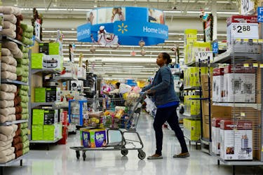A customer pushes her shopping cart through the aisles at a Walmart store in the Porter Ranch section of Los Angeles November 26, 2013.