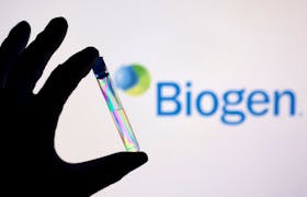 A test tube is seen in front of displayed Biogen logo in this illustration taken, December 1, 2021.