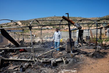 A Palestinian man inspects the damage to a house after Israeli settlers attacked the village of al-Mughayyer, in the Israeli-occupied West Bank, April 13, 2024.