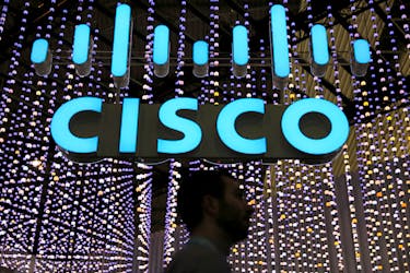 A man passes under a Cisco logo at the Mobile World Congress in Barcelona, Spain February 25, 2019.