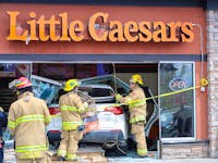 Not a drive-thru — Calgary firefighters clean up after a driver inadvertently accelerated through the front of the Little Caesars Pizza in Panorama Hills on Thursday May 16, 2024. Adjacent business workers said it was just luck that the normally busy business had no customers during the lunch-hour accident. The driver was shook up but not injured.