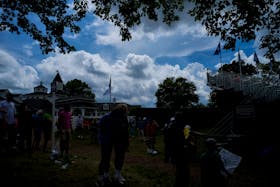 May 15, 2024; Louisville, Kentucky, USA; Clouds loom behind the clubhouse as fans gather around the ninth green during a practice round for the PGA Championship golf tournament at Valhalla Golf Club. Mandatory Credit: Aaron Doster-USA TODAY Sports