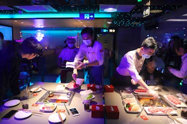 Waiters serve customers at a Haidilao hotpot restaurant in Beijing, China October 11, 2021. Picture taken October 11, 2021.