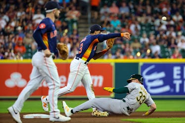 May 15, 2024; Houston, Texas, USA; Houston Astros shortstop Jeremy Peña (3) turns a double play on Oakland Athletics outfielder JJ Bleday (33) in the eighth inning at Minute Maid Park. Mandatory Credit: Thomas Shea-USA TODAY Sports