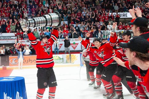 Bridgewater's Luke Woodworth raises the Gilles Courteau Trophy after the Drummondville Voltigeurs clinched the QMJHL championship in Drummondville on Monday. - QMJHL