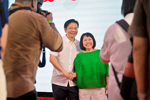 Singapore's fourth Prime Minister, Lawrence Wong, takes photos with a supporter at a community event after the swearing-in ceremony in Singapore May 15, 2024.