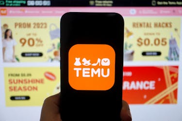The logo of Temu, an e-commerce platform owned by PDD Holdings, is seen on a mobile phone displayed in front of its website, in this illustration picture taken April 26, 2023.