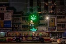 A bus drives past the neon sign of a cannabis shop in Bangkok, Thailand, August 18, 2023.