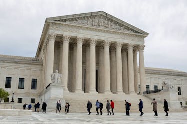 People walk across the plaza of the U.S. Supreme Court building on the first day of the court's new term in Washington, U.S. October 3, 2022. 