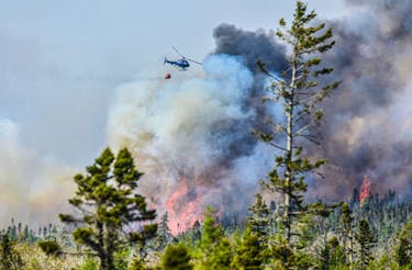 A Department of Natural Resources and Renewables helicopter releases water over a wildfire burning out of control in the Barrington/Clyde River region of Shelburne County on Sunday, May 28, 2023. Frankie Crowell photo
