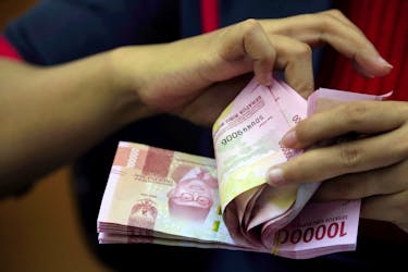 An employee counts Indonesian rupiah banknotes at a currency exchange office in Jakarta, Indonesia October 23, 2018. Picture taken October 23, 2018.