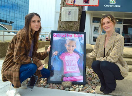 Payton Williams, left, and Sam Williams kneel next to a memorial for their sister Talia Forrest outside the Sydney Justice Centre on Friday after Colin Tweedie was found guilty on three charges related to the death of Forrest, 10, who died after she was hit by an SUV driven by Tweedie on July 11, 2019. Chris Connors/Cape Breton Post