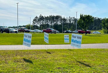 Signs urge the workers to vote line the road leading up to the Mercedes plant in Vance, Alabama, U.S., May 16, 2024.