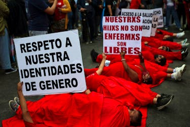 A group of protesters carry signs at a protest by the LGBTQI community against a new government decree listing transsexualism as a "mental disorder", in front of the Ministry of Health, in Lima, Peru May 17, 2024.