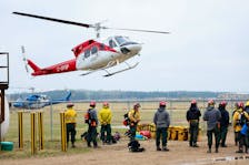 Alberta wildfire crews wait to load into a helicopter to fly to the fire line two days after a wildfire caused the evacuation of communities on the southern edge of Fort McMurray, Alberta, Canada May 16, 2024.