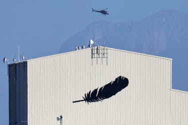 A helicopter flies over a building featuring Blue Origin's logo near Van Horn, Texas, U.S., October 13, 2021.