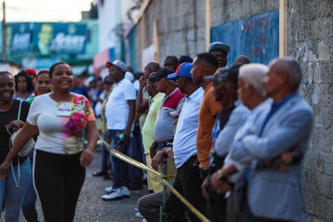 People wait outside a school used as a polling station, to cast their votes, on the day of the presidential election in Santo Domingo, Dominican Republic May 19, 2024.