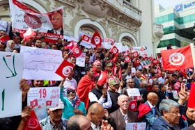 Supporters of Tunisian President Kais Saied carry flags and signs during a demonstration to show their support for him and to reject what they say is "foreign interference", in Tunis, Tunisia May 19, 2024.