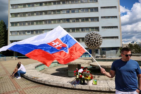 A supporter holds a flag of Slovakia near the F.D. Roosevelt University Hospital, where Slovak Prime Minister Robert Fico is hospitalised following an assassination attempt, in Banska Bystrica, Slovakia, May 18, 2024.